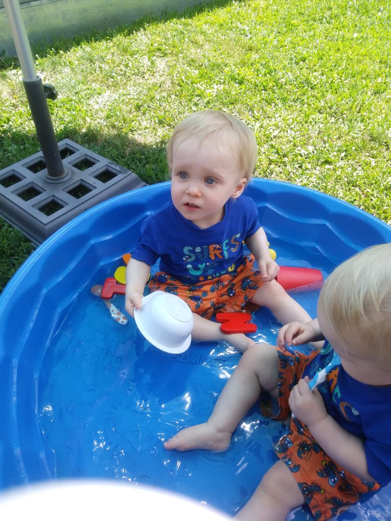 The Twins in their kiddie pool, playing