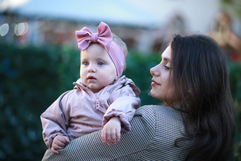 Woman holding baby girl wearing pink