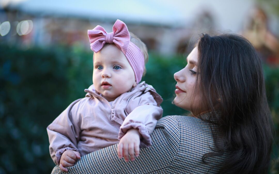 Woman holding baby girl wearing pink